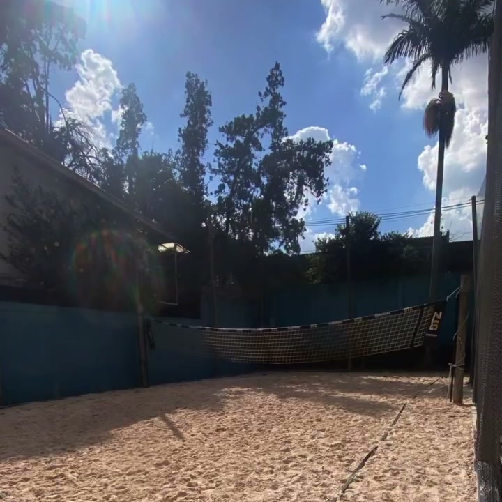 Quadra de areia do Mareva num dia de sol, com palmeiras ao fundo