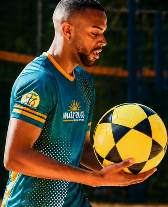 Professor Vinny segurando uma bola de futevôlei